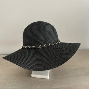 Stylish black woven brimmed hat with gold tone chain trim